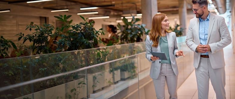 Two banking professionals discuss strategy while walking, representing collaboration through regulatory and market change.