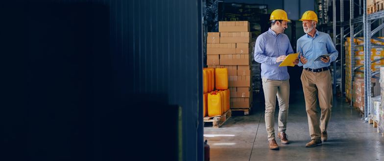 Construction professionals walk through a warehouse, representing collaboration amid changing regulations and market conditions.