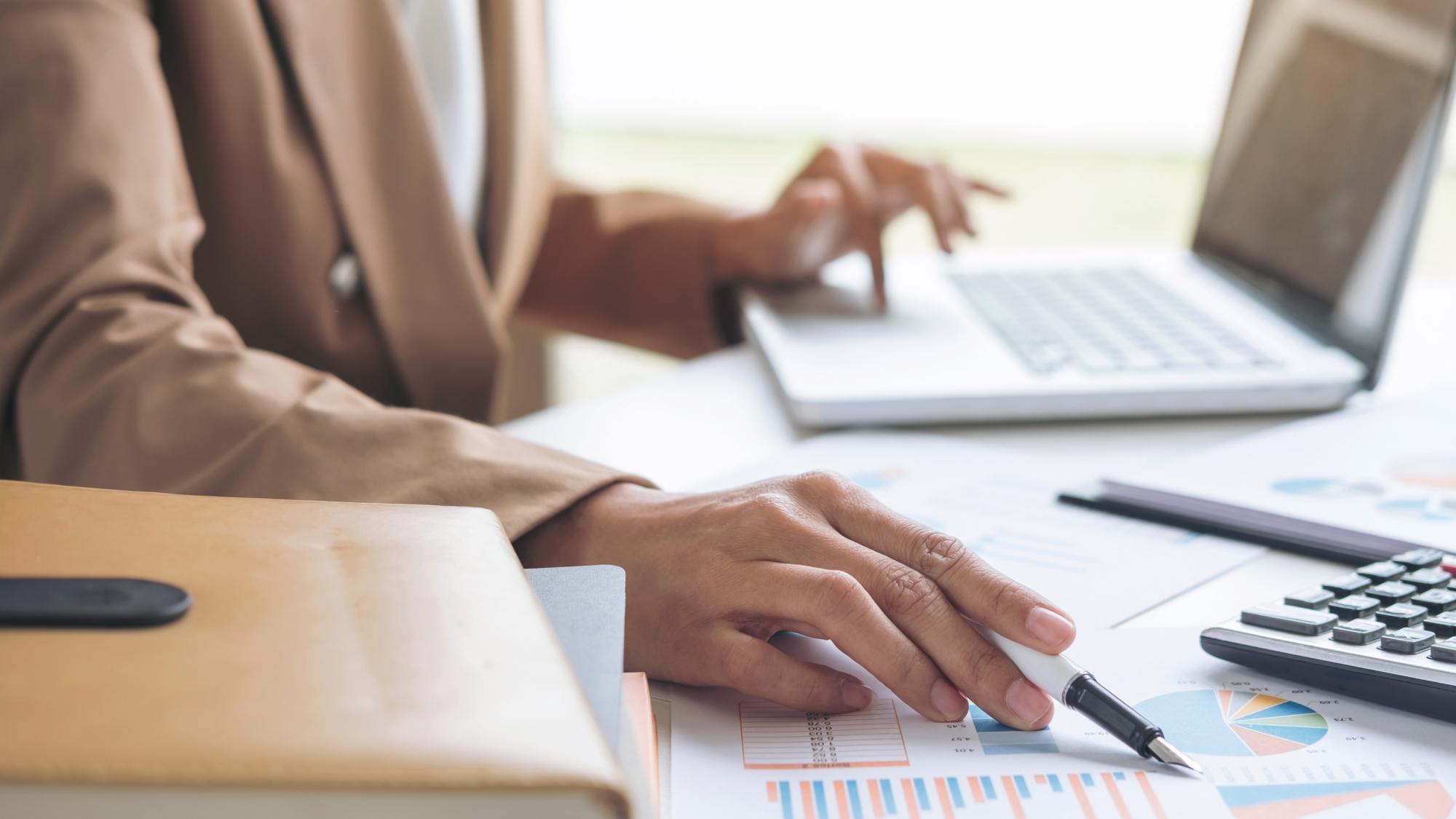 Internal auditor highlights charts on a paper while performing independent testing