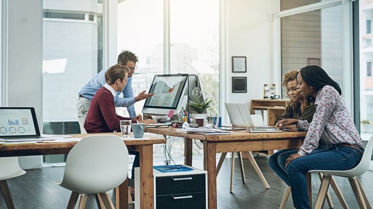 Team members collaborate on data and visuals, representing a phased approach to AI adoption in public sector organizations.