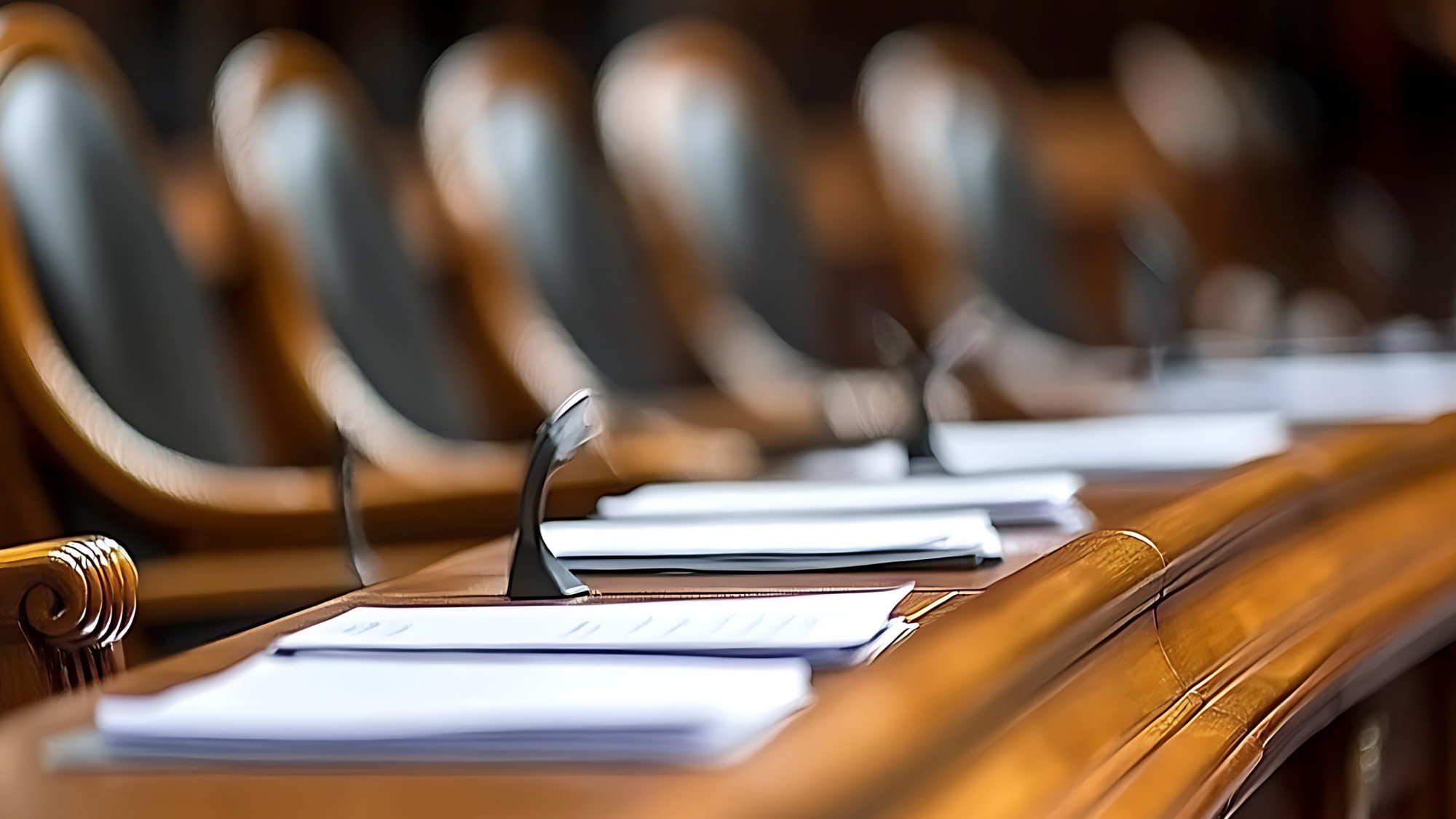 Rows of wooden chairs arranged in a courtroom setting, emphasizing the formal atmosphere of legal proceedings.