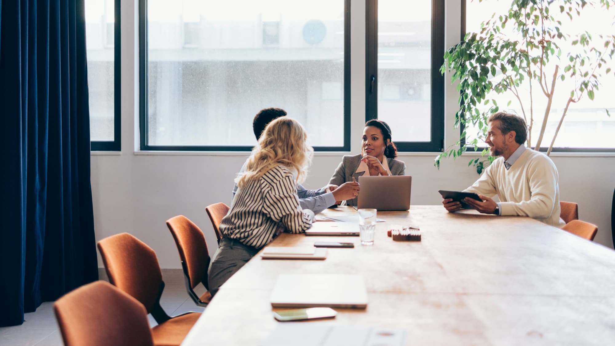 Business professionals engaged in discussion at a conference table, focusing on financial strategies for CFOs.