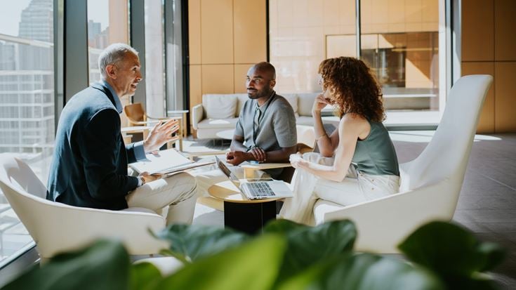 Business professionals discuss HITRUST program updates and cybersecurity compliance strategies.