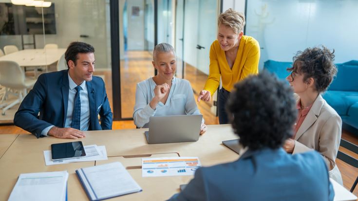 Insurance professionals review financial data during a team meeting.