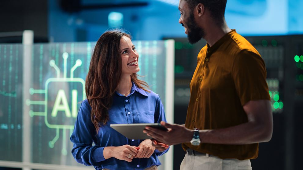 Two technology professionals collaborating with a tablet in an AI-enabled workplace, representing artificial intelligence and digital transformation.