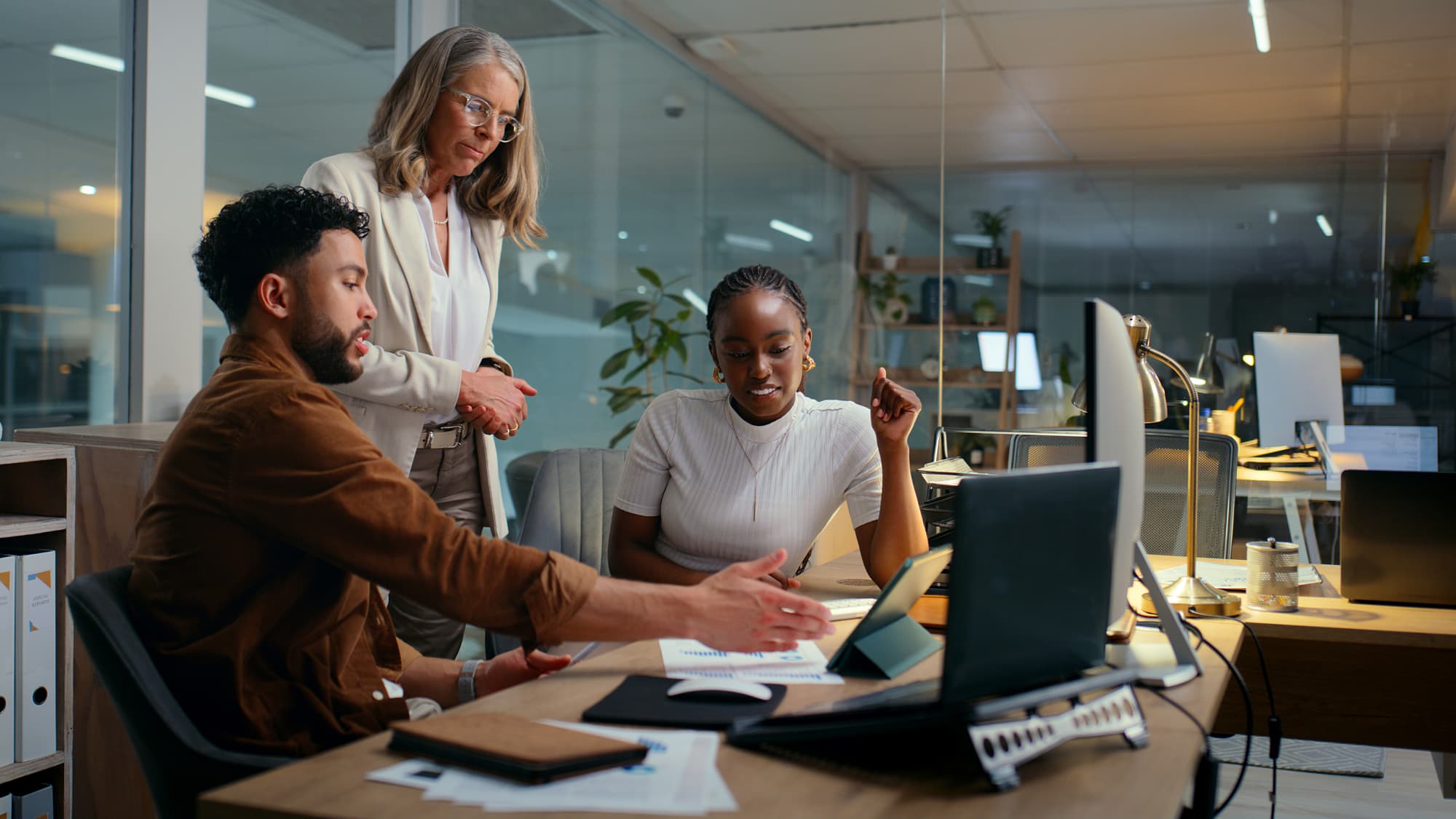 Team reviews charts and compliance materials at a shared desk, representing collaboration on unclaimed property law requirements.