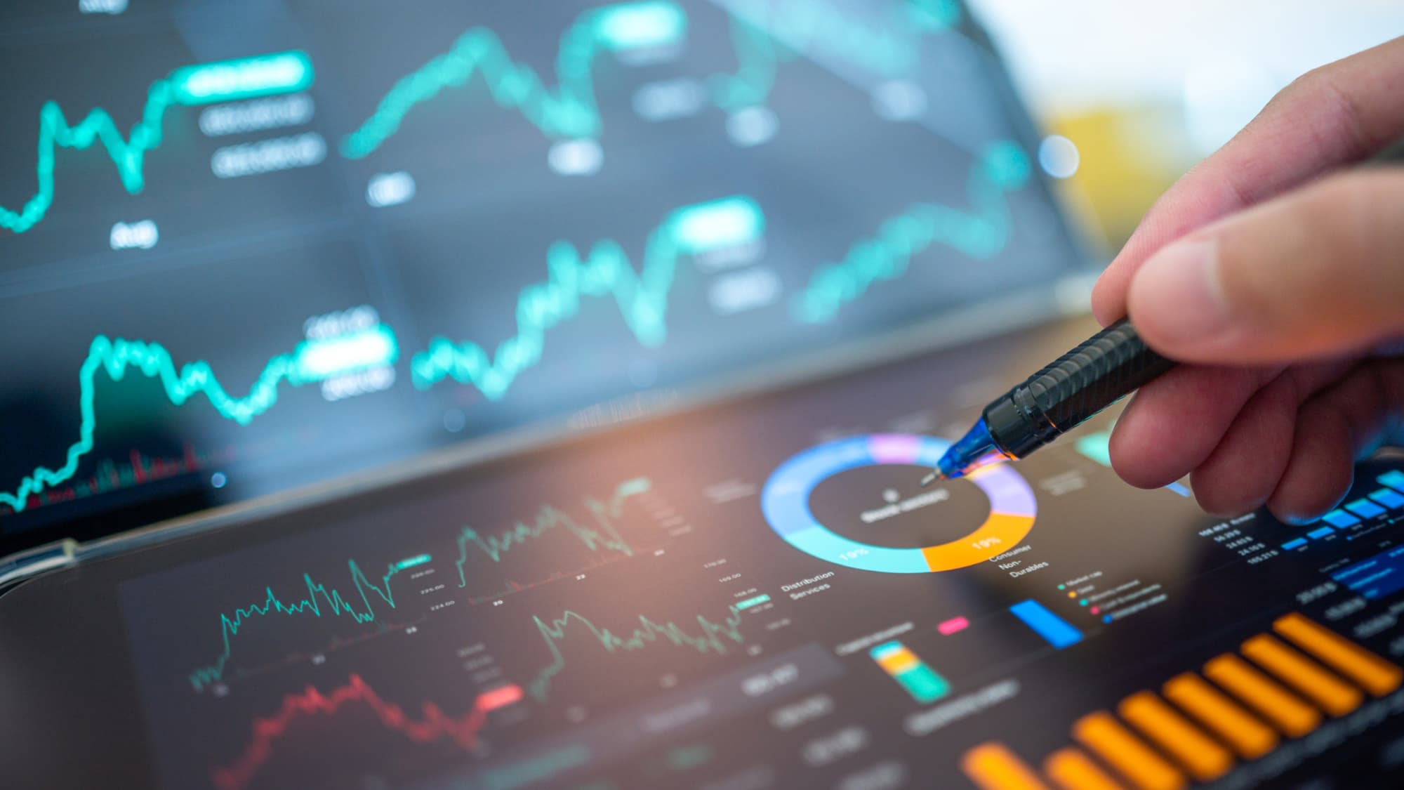 Hand points to financial charts and dashboards, symbolizing economic trends and tax considerations shaping private equity decisions.