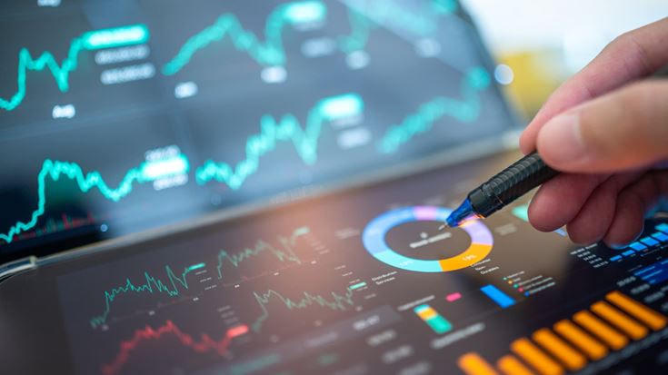 Hand points to financial charts and dashboards, symbolizing economic trends and tax considerations shaping private equity decisions.