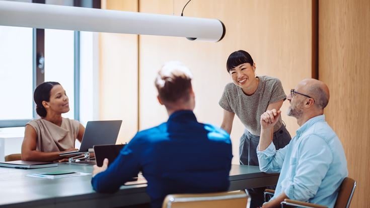 Team collaborates in a meeting, representing AI-powered business reporting and data insights with Crowe Data Concierge.