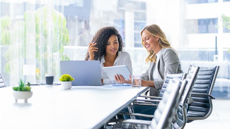 Finance professionals review digital reporting data, supporting AI governance and auditable controls.