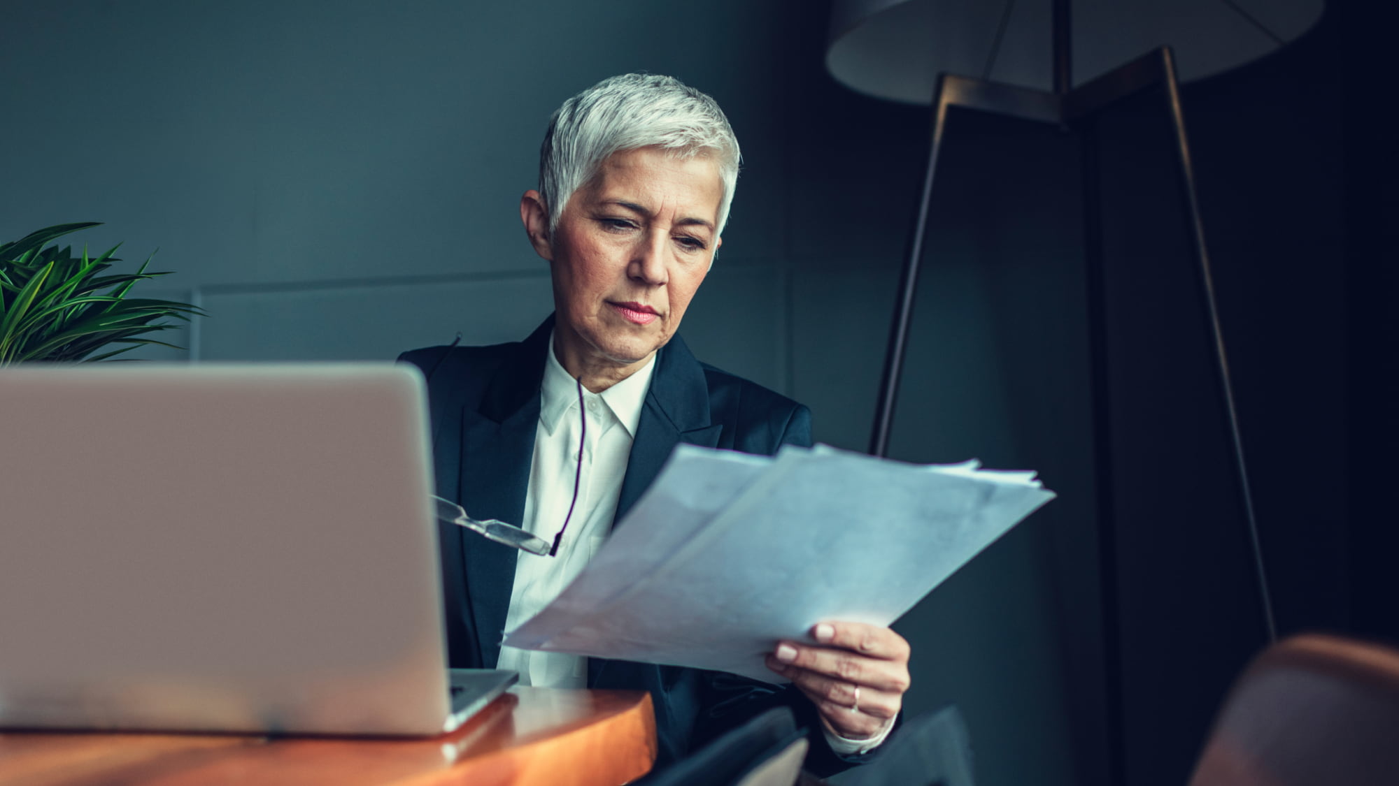 Legal professional reviews documents at a laptop, representing responsible AI governance and risk management in legal practice.