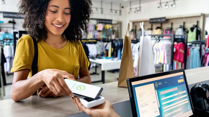 Customer pays with a digital wallet at checkout, reflecting stablecoin-driven payments and embedded finance.