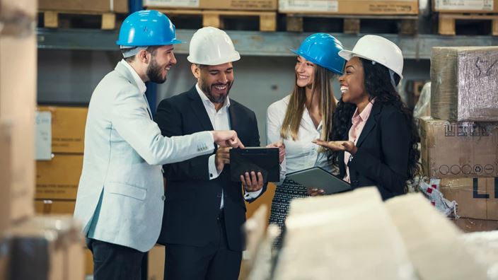 Manufacturing professionals reviewing pricing data in a warehouse