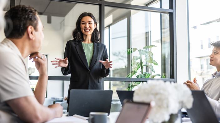 Compliance leader presents automation and optimization strategies during a team meeting.