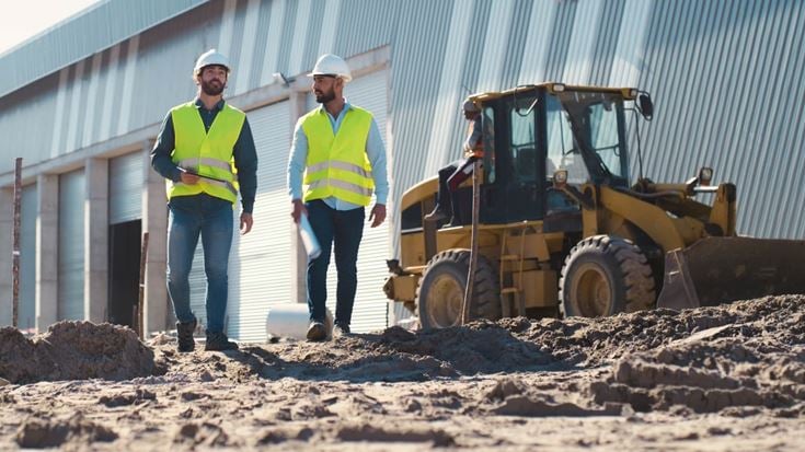Construction team inspects a manufacturing facility project, supporting planning for QPP-eligible investments and accelerated tax deductions.