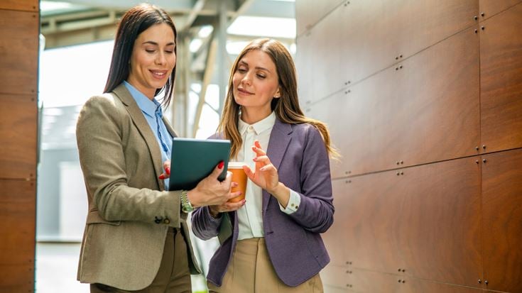 Two insurance professionals review information on a tablet, reflecting collaboration and strategic planning.