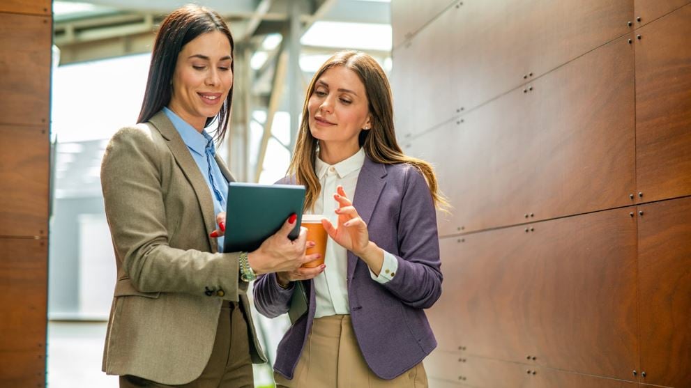 Two insurance professionals review information on a tablet, reflecting collaboration and strategic planning.