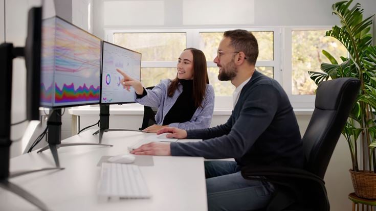 Team reviews AI-driven analytics on screens to inform tax decisions and strategy.