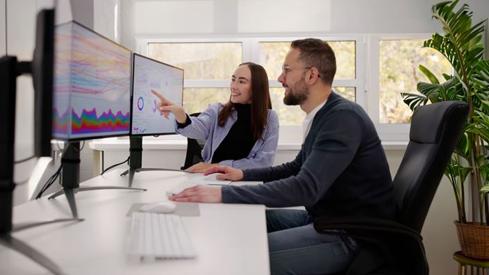 Team reviews AI-driven analytics on screens to inform tax decisions and strategy.
