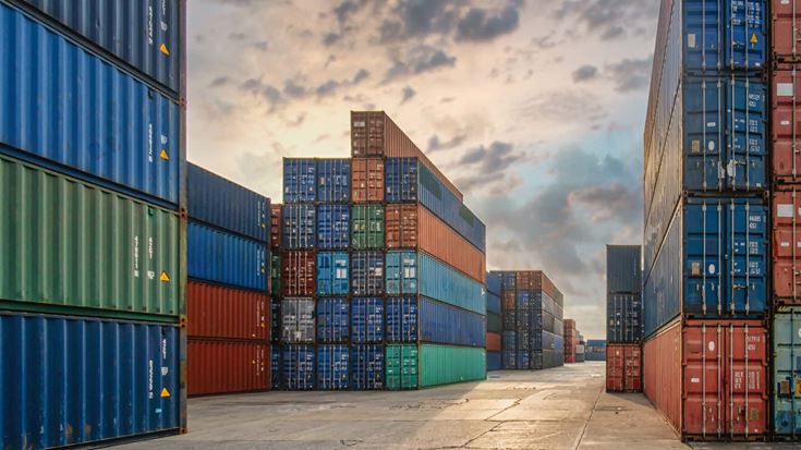 Stacked containers in a warehouse, illustrating logistics for executives focused on trade policy impacts.
