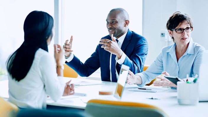 Business professionals in discussion, reflecting collaboration on AI strategy in private equity.