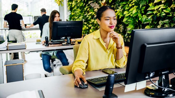 Professional working at computer in modern office, representing tech-enabled risk and audit strategy alignment.