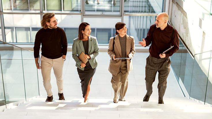 Business professionals discuss audit quality and organizational oversight while walking together.