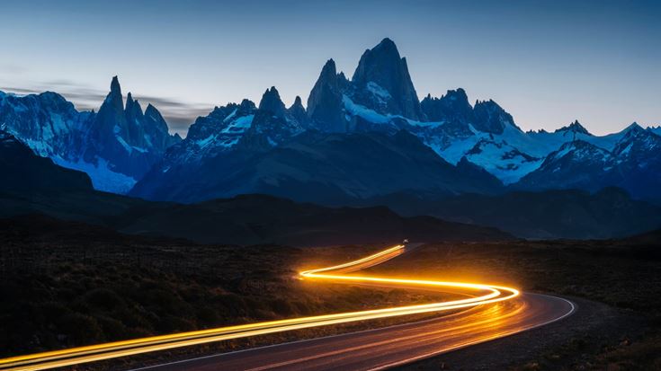 Light trail curves toward a mountain range at dusk, symbolizing Crowe’s direction, transparency, and commitment to audit quality.