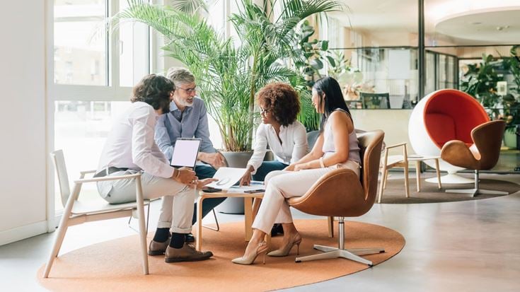 Team collaborates in a lounge setting, representing GRC transformation and scalable, audit-ready processes for a bank.