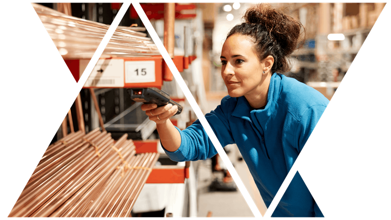 Warehouse employee scans copper inventory using an ERP system to improve supply chain visibility and customer service.