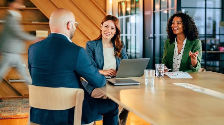 Financial services professionals collaborating during a business meeting, reviewing financial data and strategic priorities.