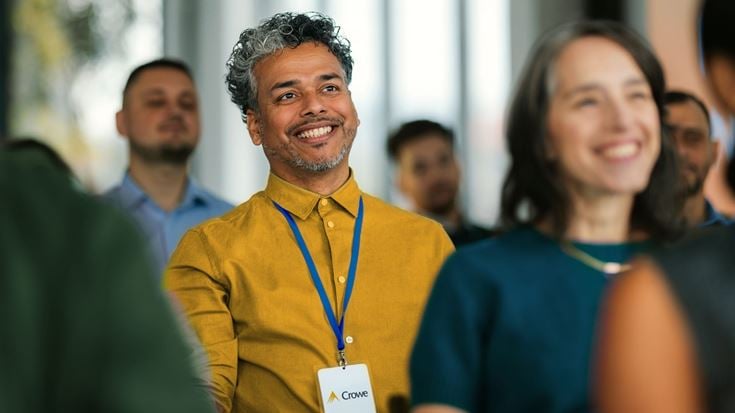 Attendees listen during a Crowe financial services conference session, highlighting networking and year-end industry insights.