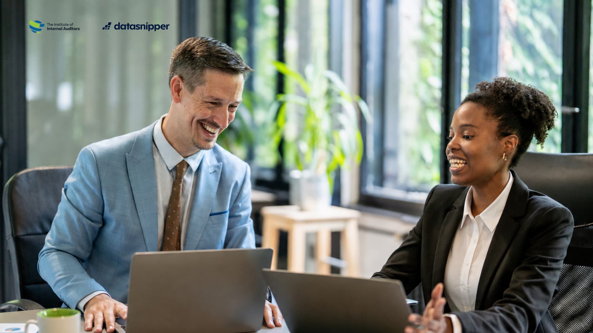 Two professionals collaborate at laptops, representing audit automation and efficiency in the public sector.