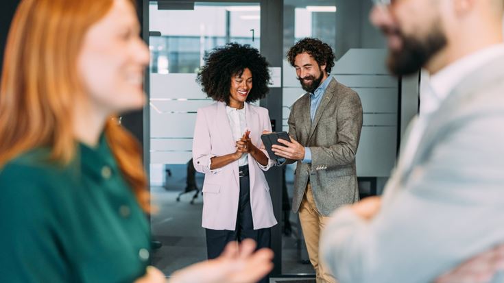 Professionals review information on a tablet, representing fintech strategy amid regulatory change and digital asset risk.
