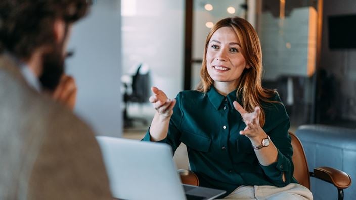 Professional discussing ideas with a colleague during a business meeting in an office.