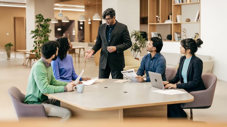 Business leader engages a diverse team in discussion, representing IPO readiness planning and regulatory preparation.