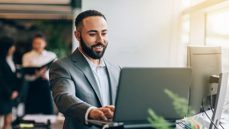 Professional using a laptop for AI-enabled financial reporting and SOX compliance work.