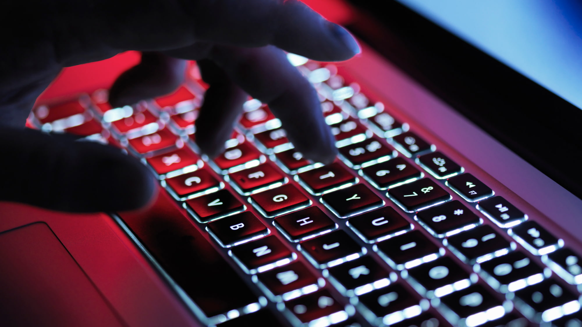 A dark mystery hand typing on a laptop computer at night researching why internal audit functions should own pen testing