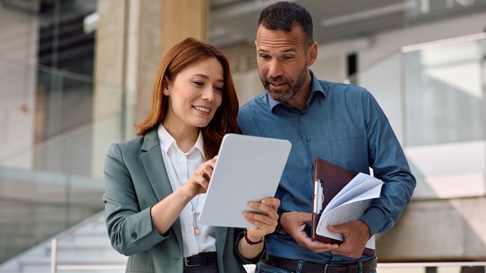 Financial services professionals review digital due diligence information related to evolving KYC and AML requirements.
