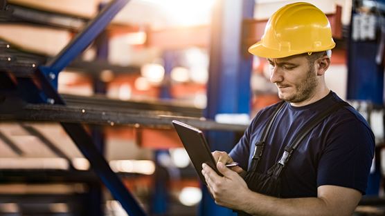 Steel worker using a tablet on the shop floor to support digital transformation in steel operations.