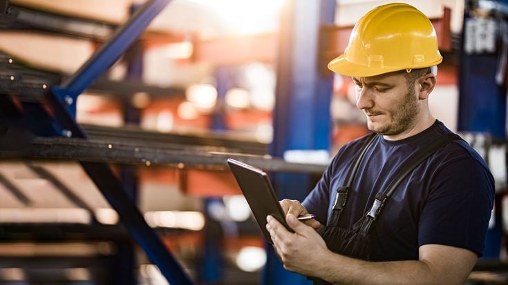 Steel worker using a tablet on the shop floor to support digital transformation in steel operations.