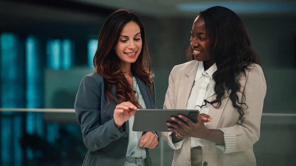 Two financial services professionals reviewing information on a tablet
