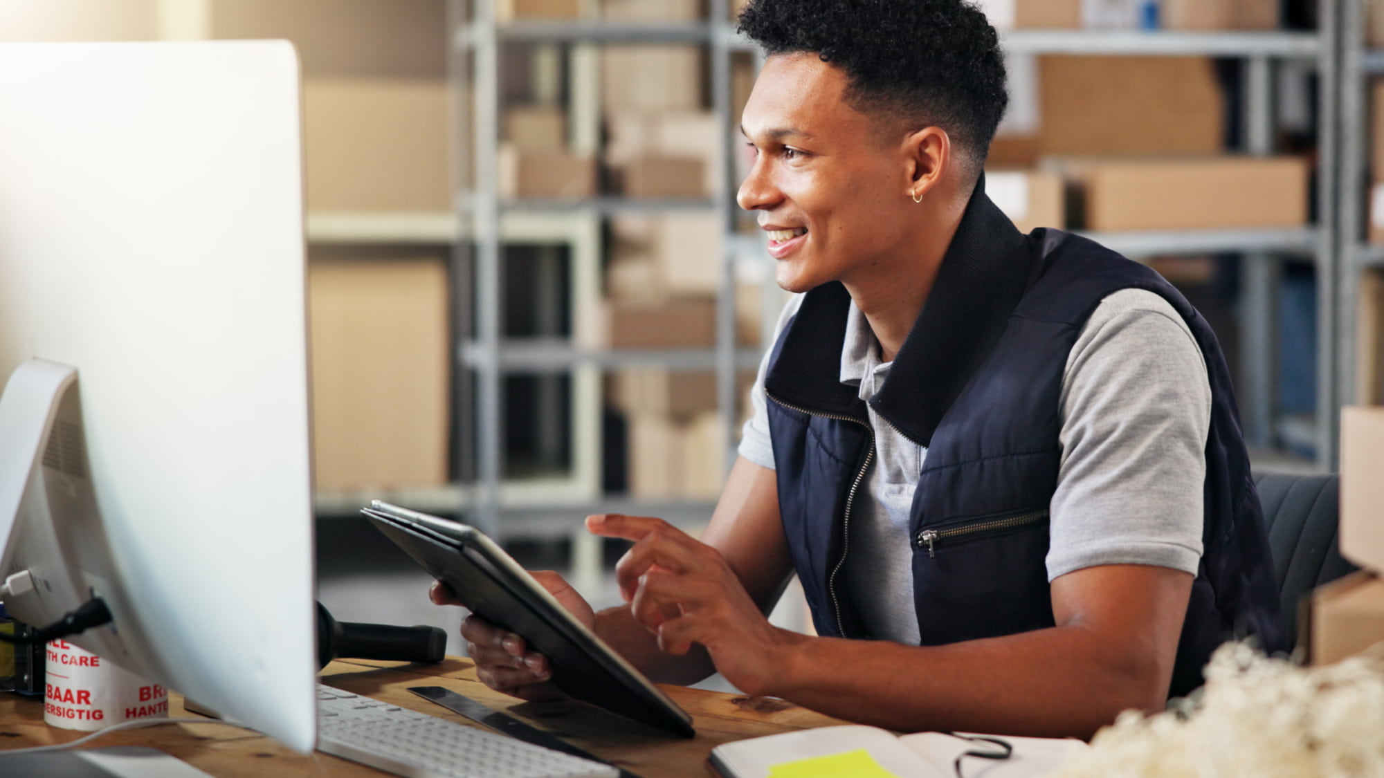 Warehouse employee reviews information on a tablet, representing tax refund claims and financial recovery planning.