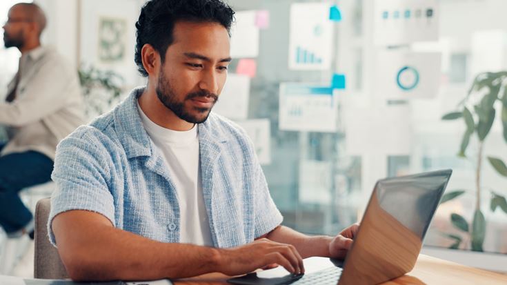 Professional using a laptop, representing evolving sales tax rules for software and SaaS.
