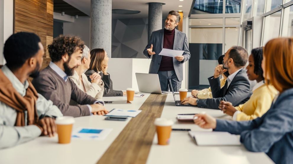 Business professionals discuss regulatory changes during a meeting in a modern conference room.