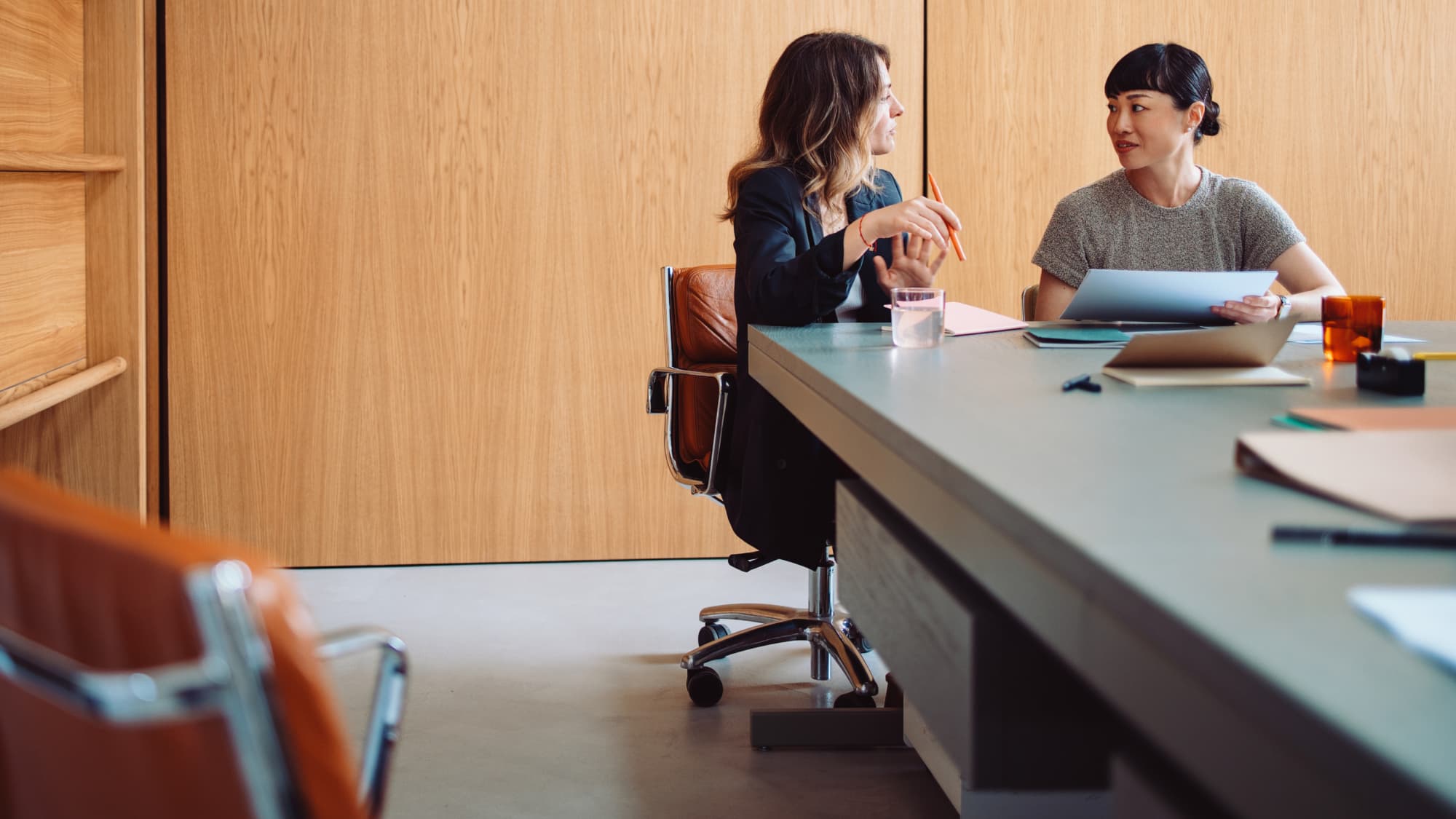 Two professionals review documents in a meeting, representing tax planning decisions related to Section 163(j) election changes.