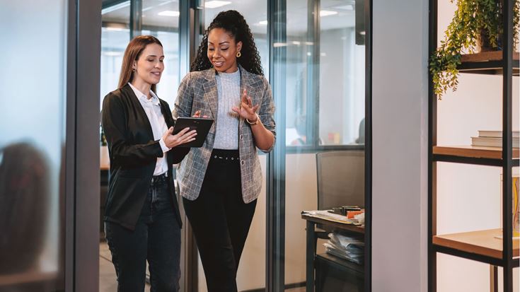 Two professionals review information on a tablet, representing collaboration on carried interest tax and income planning.