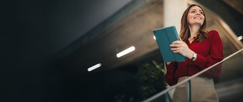 Professional holds a tablet while walking upstairs, representing proactive business risk management and strategy.