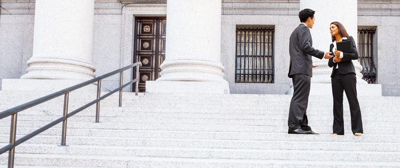 Tax professionals discuss complex tax challenges outside a government building.