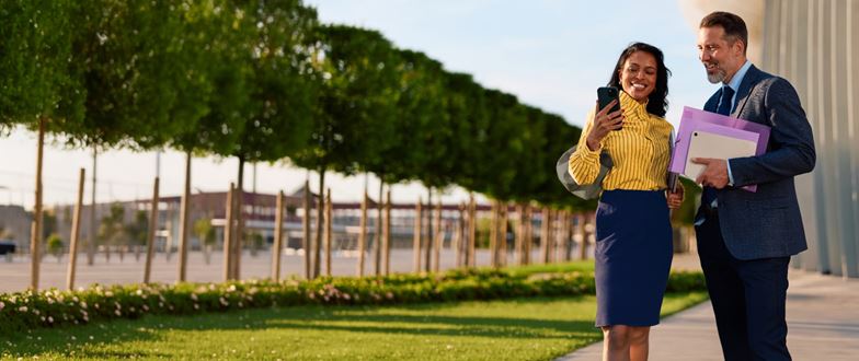 Two professionals review information outdoors, representing guidance on addressing business tax challenges.